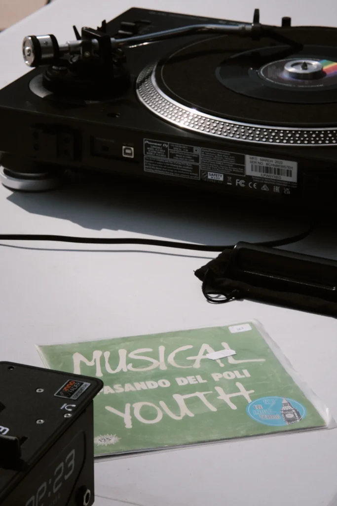 Close-up of a black Pioneer turntable and a green vinyl sleeve from the 'Musical Youth' Sound System event.