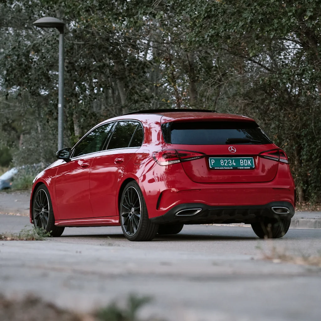 Red Mercedes-Benz A-Class (W177) hatchback rear three-quarter view, showcasing design lines, taillights, and outdoor setting.