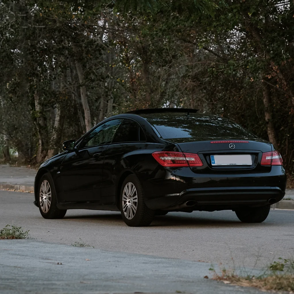 Full rear view of the black car, emphasizing the clean rear bumper, dual exhaust tips, and the width of the vehicle.
