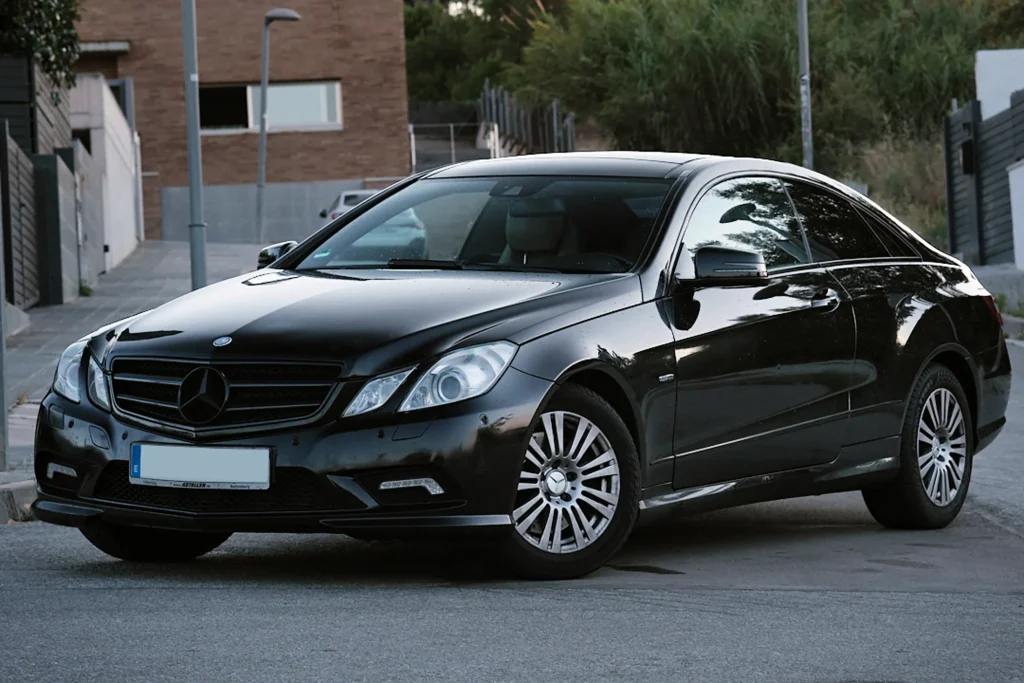 Rear 3/4 view of the black Mercedes E-Class Coupé (C207), highlighting the LED taillights and overall aggressive stance.