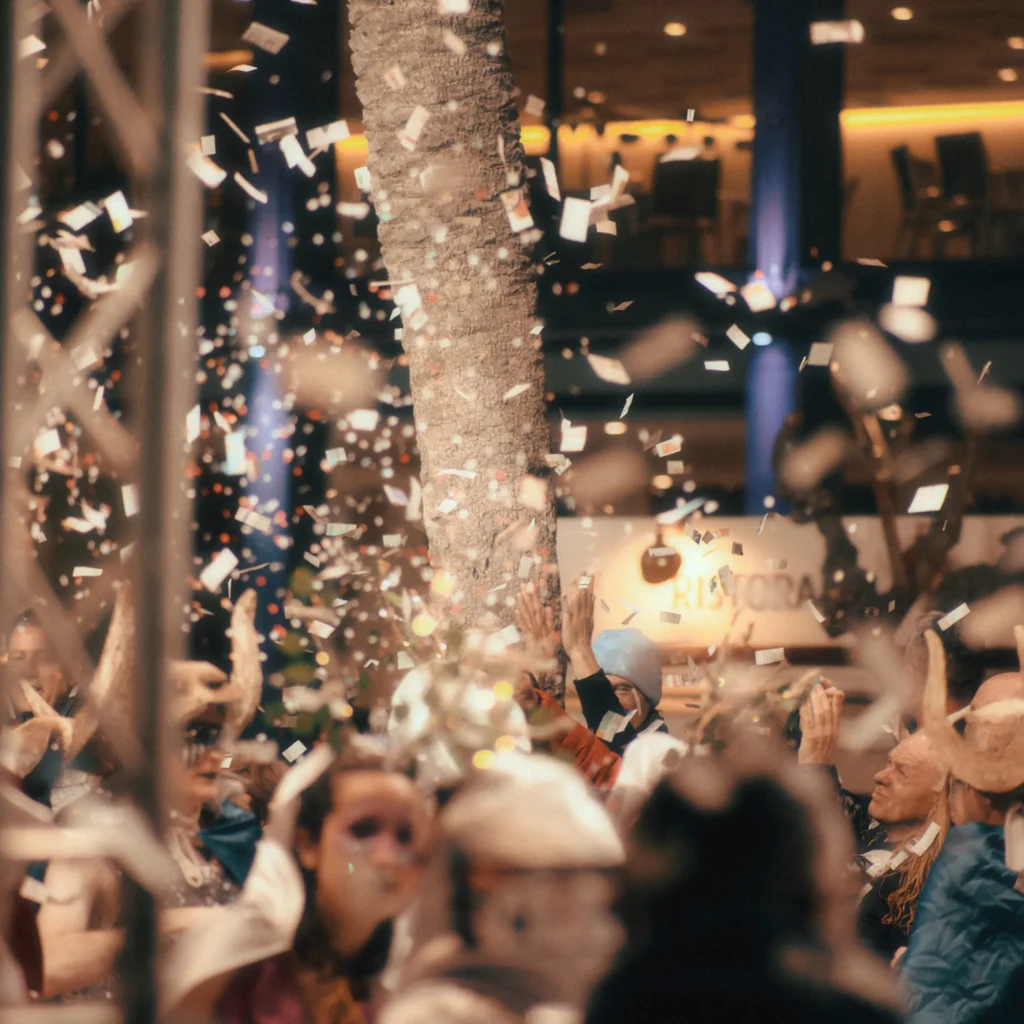 Vibrant and dynamic event lifestyle photography capturing a nightlife party scene with confetti falling over a crowd, ideal for high-end editorial content or luxury event promotion in Spain