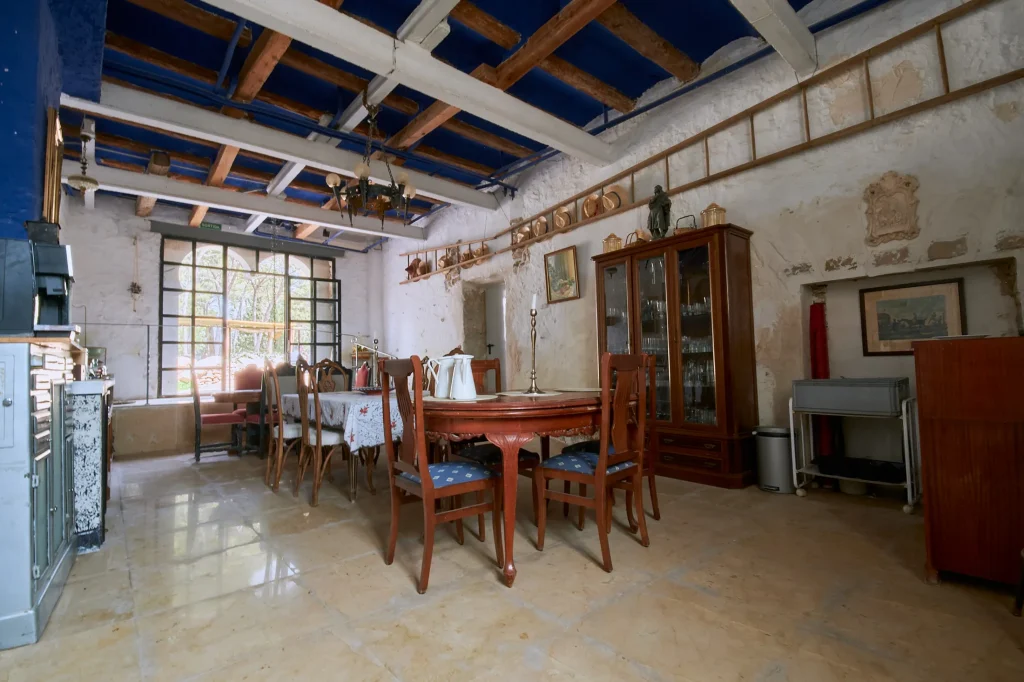 Clean and bright architectural photography of an interior living space in a luxury villa/hotel, focusing on high ceilings and modern rustic design.