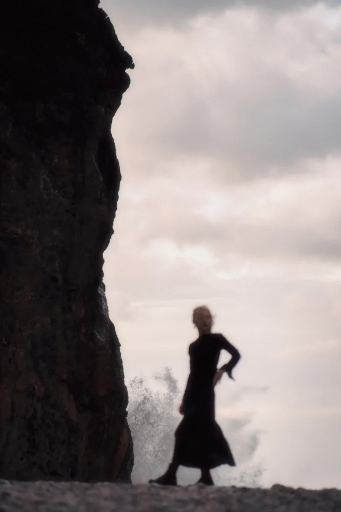 Moody, fine art portrait with a dramatic long exposure effect on the water, featuring a subject on the Mallorcan coastline.
