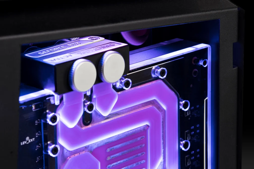 Extreme close-up of a water-cooled NVIDIA GeForce RTX graphics card block, highlighted by purple RGB lighting and silver fittings.
